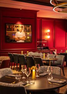 a restaurant with tables and chairs and a wall with a picture at The Cumberland, London in London +36 photos