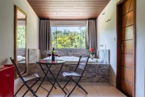 a dining room with a table and chairs and a window at Recanto de Moriá in Penedo