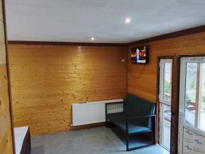 a room with a chair and a television on a wall at Paulownia Garden in Mtskheta