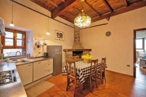 a kitchen with a table with chairs and a fireplace at La Casa del Voltone in Pontremoli
