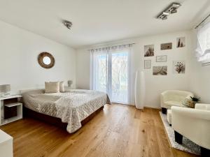 a white bedroom with a bed and a living room at Villa 124 Residence in Lignano Sabbiadoro +15 photos