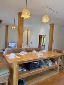 a large wooden table with two chandeliers at Peach's House in Katiet