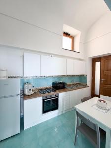 a kitchen with white cabinets and a white table with a tableablish at Nonna Liberina in Procida +25 photos