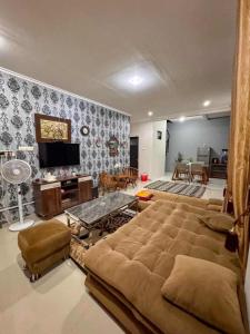 a living room with a large bed and a tv at Villa FiFa in Blimbing