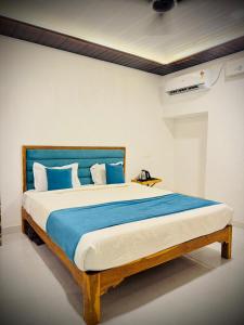 a bedroom with a large bed with blue and white pillows at Coastal Home in Diveagar