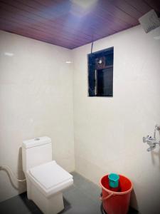 a bathroom with a white toilet and a window at Coastal Home in Diveagar