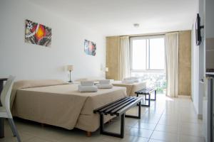 a bedroom with a bed and a couch and a table at Torre Potosi Departamentos in Rosario