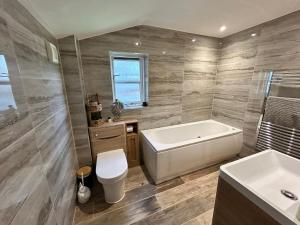 a bathroom with a tub and a toilet and a sink at Looe, Cornwall, couples, families, quiet location, views, reliable Wi-Fi, 3 bed LANGUNNETT COTTAGE in Looe +54 photos