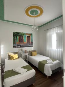 a bedroom with two beds and a ceiling at Casa do Ti Luís in Leiria