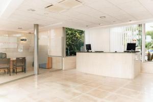 an office lobby with a reception desk and a table at BLUESEA Paraiso Beach - Adults Only in Es Cana