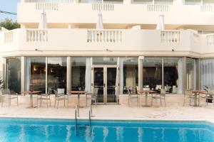 a hotel with a pool and tables and chairs at BLUESEA Paraiso Beach - Adults Only in Es Cana +19 photos
