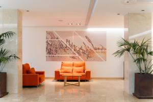 an office lobby with an orange chair and a painting at BLUESEA Salina Ex MD Atlantic in Es Cana