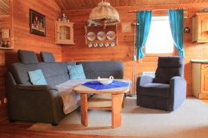 a living room with a couch and a chair and a table at Ferienhaus-Kuenzel in Viechtach