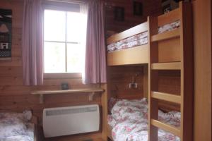 a bedroom with two bunk beds and a window at Ferienhaus-Kuenzel in Viechtach