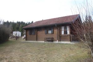 a small wooden house with a bench in a yard at Ferienhaus-Kuenzel in Viechtach