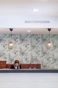 a woman is sitting in a waiting room at BLUESEA Calabahía in Cala del Moral +63 photos