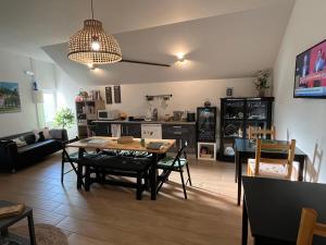 a living room with a table and chairs and a kitchen at Casa do Ti Luís in Leiria