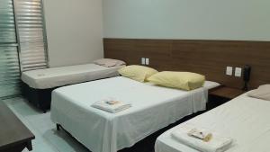 a room with three beds with white sheets at Center Plaza Hotel in São Paulo +34 photos