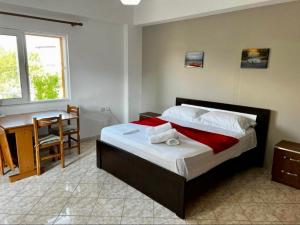 a bedroom with a bed and a table and a desk at Dimora Seaside Apartments in Ksamil