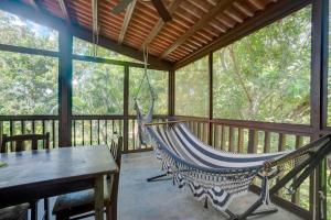a hammock in a screened in porch with a table at Vacation Home in Pedasí Town