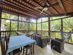 a porch with a table and chairs and a hammock at Vacation Home in Pedasí Town