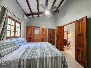 a bedroom with a bed with a blue and white comforter at Vacation Home in Pedasí Town
