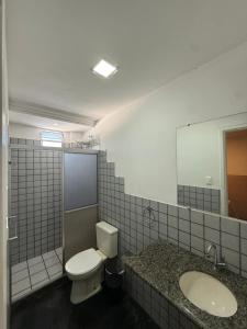 a bathroom with a toilet and a sink and a mirror at Hotel Bela Vista in Salvador