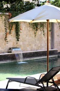 a chair and an umbrella next to a fountain at La Colongette in Antsirabe +5 photos