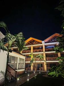 a building with palm trees in front of it at La Colongette in Antsirabe