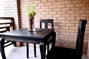 a black table with a vase of flowers on it at La Colongette in Antsirabe