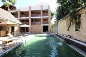a swimming pool with a fountain in front of a building at La Colongette in Antsirabe