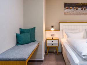 ein Schlafzimmer mit einem Bett und einem Nachttisch neben dem Bett in der Unterkunft PLAZA Premium Sylt in Wenningstedt-Braderup + 36 Fotos