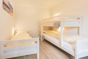 two bunk beds in a small room with wooden floors at Feriendomizil-SeeSand in Gammendorf