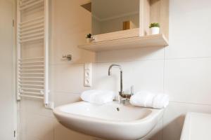 a white bathroom with a sink and a mirror at Feriendomizil-SeeSand in Gammendorf +14 photos