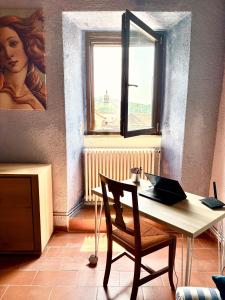 a table and a chair in a room with a window at La Casa del Voltone in Pontremoli +21 photos