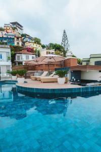 a swimming pool with chairs and umbrellas on a building at Hotel Rio Guayas by Art Hotels in Guayaquil