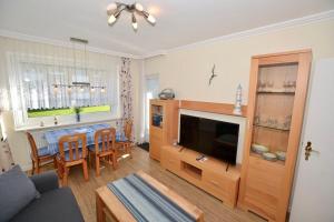 a living room with a television and a dining room at Appartement-124 in Westerland +2 photos