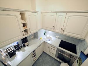 a small kitchen with white cabinets and a sink at Appartement-124 in Westerland
