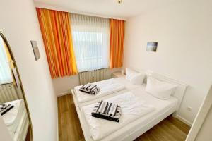 a white room with two beds with towels on them at Appartement-162 in Westerland