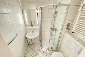 a bathroom with a shower and a toilet and a sink at Appartement-162 in Westerland