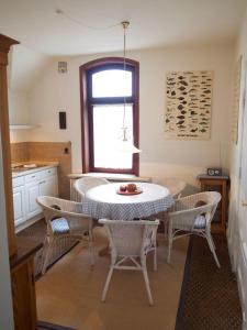 a kitchen with a table and chairs and a window at Haus-Bockelmann in Westerland +12 photos