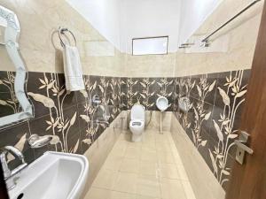 a bathroom with a toilet and a sink at Luxury Palm Stay in Jammu