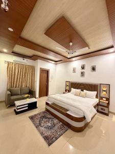 a large bedroom with a large bed and a couch at Luxury Palm Stay in Jammu
