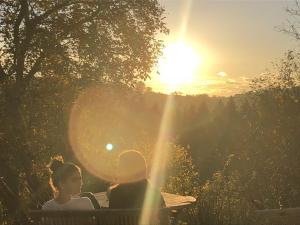 two people sitting on a bench watching the sunset at Weitblick am Mangfalltal in Feldkirchen-Westerham