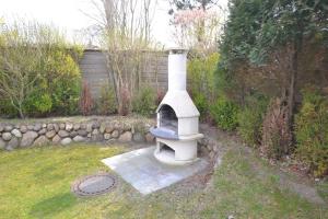 a stone oven in a yard next to a wall at Haus-Neumann in Westerland