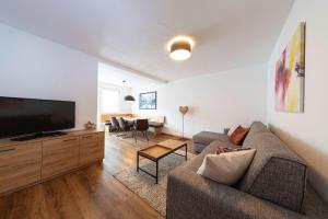 a living room with a couch and a flat screen tv at Pension Hofer in Brunico