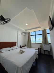 a bedroom with two beds with a teddy bear on it at Hotel Bela Vista in Salvador