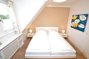 a white bed in a room with a window at Syltstyle-12 in Tinnum