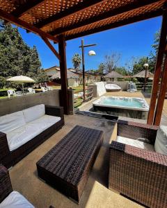 a patio with wicker furniture and a swimming pool at El Copihue Olmué in Olmué