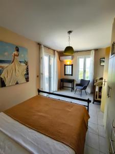 a bedroom with a bed and a painting of a woman at Villa Eytychia in Kefallonia